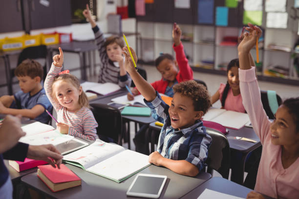 Dziecko podnoszące rękę podczas zajęć edukacyjnych